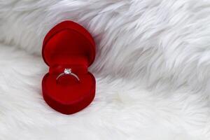 Diamond Ring in Heart-Shaped Box on fur white blanket photo