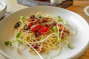 Spaghetti aglio e olio, Traditional Italian Pasta with dried chilli, olive oil and crispy bacon flakes on top photo