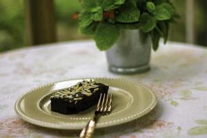 Homemade chocolate brownies in a golden yellow ceramic plate on the table, in a coffee shop, Homemade brownies with almond petals, Chocolate brownie squares. photo