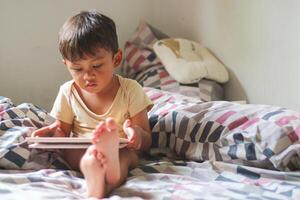 Kids with tablet computer. Child with pc watching movie or playing game. Educational online program for school child. Boy with digital device and gadget. Screen time and education for young kid. photo