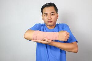 Broken hand injury, Asian man with hand operation with pressure bandage in hospital building, Hand with wrapped plaster and arm sling. photo