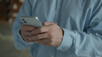 Close up Caucasian businessman man business client user client male hands typing message texting holding mobile phone cellphone using smartphone scrolling browsing internet online apps indoors office video