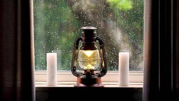 Relaxing Christmas scene with lit lantern and ditches and rain running down the window pane video