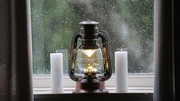Relaxing Christmas scene with lit lantern and ditches and rain running down the window pane video