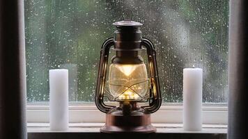 Relaxing Christmas scene with lit lantern and ditches and rain running down the window pane video