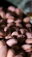 beer with pistachios Slow motion handheld shot of apple cider in glass and pistachios in black bowl on concrete countertop video