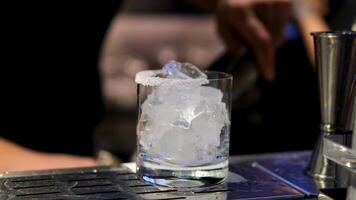 Cooking process Step by step Close up of a professional bartender is mixing gin tonic with professional crystal ice cubes to customers at the bar or disco club. video