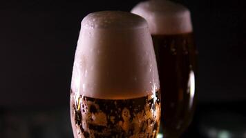 foam flows down a glass of beer Beer in a beer glass, forming effervescent. Beer foam flows down the glass. . Detail shot, macro. beer capturing the spirit of octoberfest celebration . alcoholic drink video