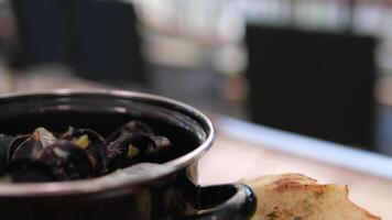 pot with shellfish mussels Cooked mussels in a pot. Seafood, toasts and lemon. video
