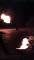 twists a long rope with a flame at the end and throws it far in different directions. Fire show artist video
