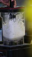 Worker at food factory preparing ice cream using a professional blender in bucket mixing cold cream. Handmade preparing ice cream. video