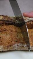 baguette of black rye bread lies on a wooden table, next to cut pieces of baguette. Panorama. The concept of baking, fresh fragrant bread to the table video