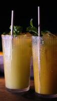 Refreshing mint cocktails with straws served in clear glasses at a bar, creating vibrant and fresh atmosphere for a summer event or party video