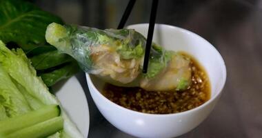 Spring roll dipped into sauce repeatedly video