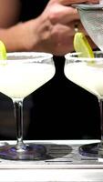 Closeup hand bartender using strainer in vodka coconut smooth fizzy cocktail at luxurious counter preparation making special to guest at fronted bar. Special refresh showcasing nightlife. Vinosity. video