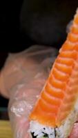 cook Philadelphia roll Step by step women's hands in transparent gloves roll add cucumber cheese Philadelphia sheets Nori rice and lightly salted fish trout or salmon video