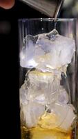 add alcohol to ice slow motion of pouring whiskey or rum with camera motion. Filmed on high speed cinema camera video