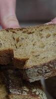 Stangenbrot von schwarz Roggen Brot Lügen auf ein hölzern Tisch, Nächster zu Schnitt Stücke von Stangenbrot. Panorama. das Konzept von Backen, frisch duftend Brot zu das Tabelle video
