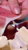 ham and brie cheese Jamon or dry-cured ham produced in Spain texture close up. 4K resolution Food background. Hand in glove take thin slice of jamon video