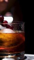 Hands, bartender and lemon in cocktail for drink preparation, beverage and closeup in pub. Alcohol, glass and barman with fruit slice on ice to garnish old fashioned whiskey on rocks for decor or art video