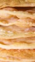 A stack of layers cakes for caramel cake on cooling rack. stack of cake layers spreads cream on the cake layers. Stacks layers one on top of the other. Nearby ingredients for making the cake video