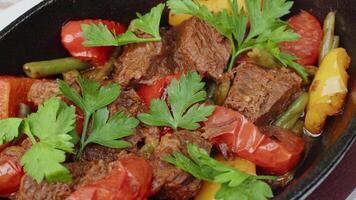 Beef stew in frying pan on table, close up view video