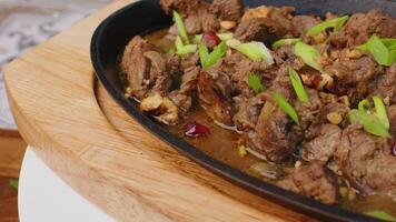 Beef stew in frying pan on table, close up view video