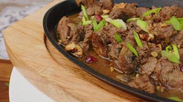 Beef stew in frying pan on table, close up view video