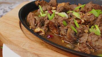 Beef stew in frying pan on table, close up view video