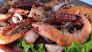 Delicious platter of seafood and fried fish on a table overlooking beach video
