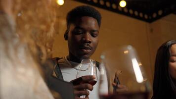Friends enjoying a lively gathering with drinks at a cozy location during the evening atmosphere video