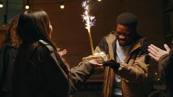 Celebrating a special moment with cake and sparklers during a joyful gathering at night video