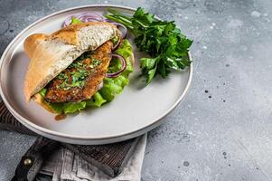 Balik Ekmek Turkish fish sandwich with grilled mackerel fillet in a bun. Gray background. Top view. Copy space photo