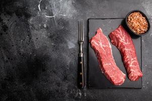 Raw Tri Tip Steak from Black Angus beef meat . black background. top view photo