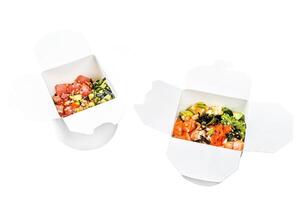 Buddha bowl in paper box with vegetables , salmon and tuna. street food to go, take away. Isolated on white background. Top view. photo