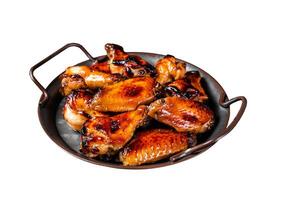 BBQ chicken wings in dip Barbecue sauce. Isolated on white background. photo