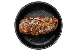 Fried lamb leg meat steak in a pan. Isolated on white background. photo