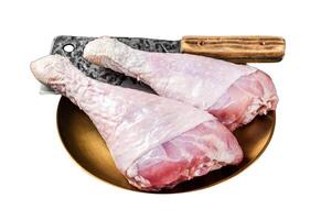 Fresh turkey legs Drumsticks, raw Poultry meat with butcher cleaver. Isolated on white background. Top view. photo