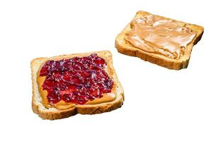 Peanut butter and jelly on white bread toasts. Isolated on white background. photo