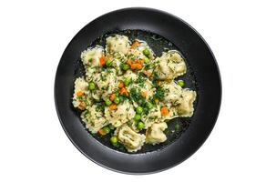 Dumplings Soup with Ravioli pasta in a bowl with greens. Isolated on white background. photo