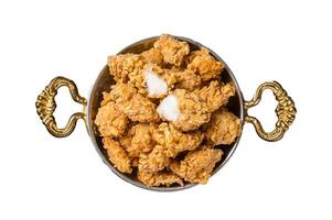 Homemade Crispy Popcorn Chicken bites in a skillet. Isolated, white background. photo