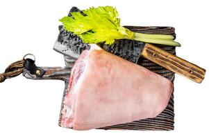 Fresh Raw pork shank knuckle on a butcher board with herbs for cooking. Isolated, white background. photo