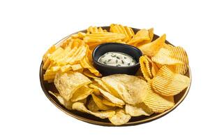 Variety of Potato chips in a plate served with dip sauce. Isolated on white background photo