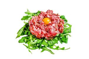 Beef tartare with arugula and quail egg. Isolated on white background, Top view. photo