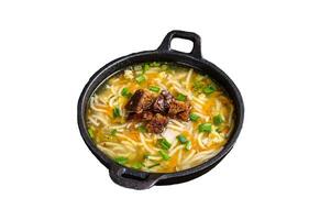 Chicken soup with noodles and vegetables. Isolated on white background, top view. photo