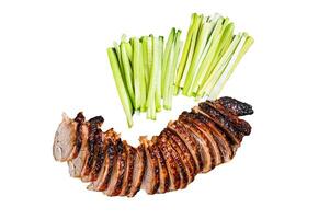 Sliced Peking Duck served with cucumber, green onion, and wheaten chinese pancakes on a meat cleaver. Isolated, white background. photo