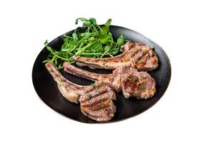 Roasted lamb meat cutlets, mutton chops with garnish. Isolated on white background. Top view. photo