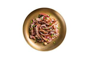 Asian appetizer pig pork ears with sesame seeds, green onion and spicy sauce. Isolated on white background. photo