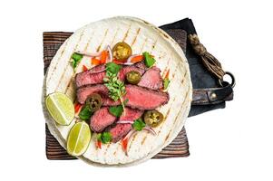Tacos of mexican beef fajitas alambre with onion, jalapeno and bell pepper. Isolated, white background photo