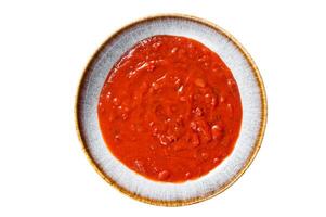 Homemade tomato Passata in rustic plate with herbs. Isolated on white background photo